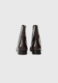 Καφέ δερμάτινα μποτάκια μέχρι τον αστράγαλο με λείο φινίρισμα, που διαθέτουν φερμουάρ στο πίσω μέρος, ελαφρώς στρογγυλεμένη μύτη και χαμηλό τετράγωνο τακούνι.