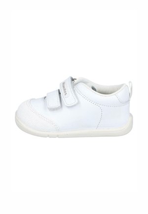 Zapatilla blanca con una puntera texturizada, dos tiras de velcro y una suela acolchada. Presenta una tira en el reverso para facilitar su uso.