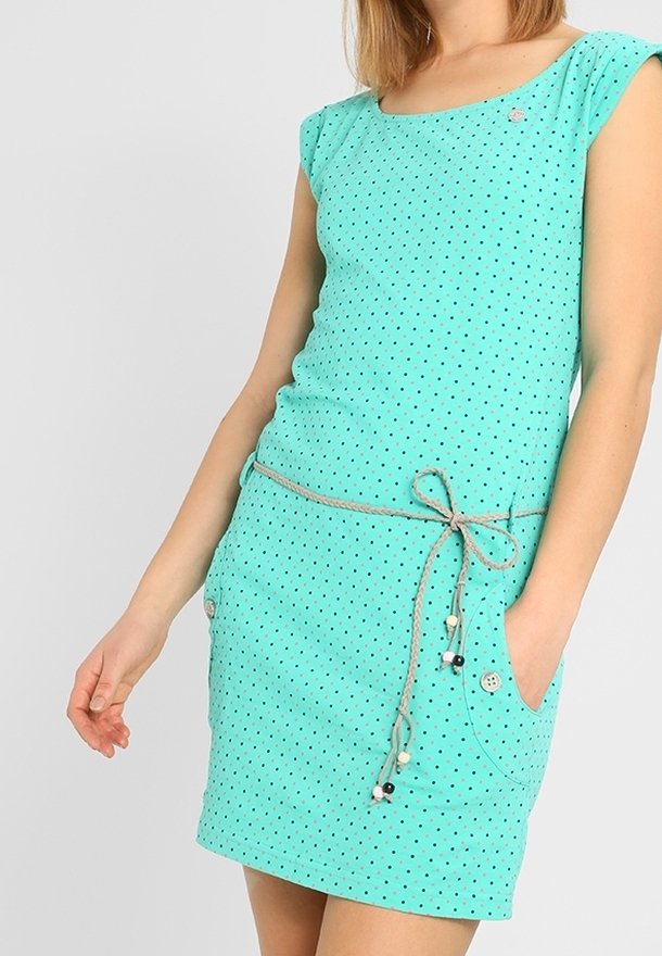 Ljust turkos klänning med korta ärmar, svarta prickar, resårmidja med snörning och sidofickor med knappaccent.