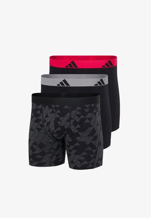 Trzy pary męskich bokserek w kolorze czarnym: jedna z szarym geometrycznym wzorem, jedna z szarą gumką, oraz jedna z czerwoną gumką, wszystkie z logo Adidas.