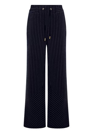 Weite Hose aus dunkelblauem Cord mit weißen vertikalen Streifen. Mit einem Kordelzugbund und einem schräg geschnittenen Saum für ein geometrisches Muster.