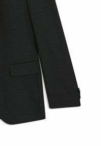 Svart kavaj med texturerat mönster, notchkrage, ficka på bröstet och knäppta ärmar. Skräddarsydd design med strukturerad silhuett.