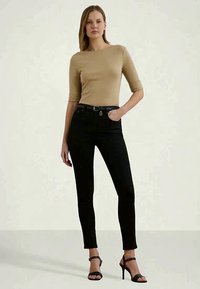 Beidzis topo beidžā ar trīs ceturtdaļu piedurknēm apvienots ar melnajām skinny džinsiem un melnām augstpapēžu sandālēm. Vienkāršs dizains, gluda tekstūra.