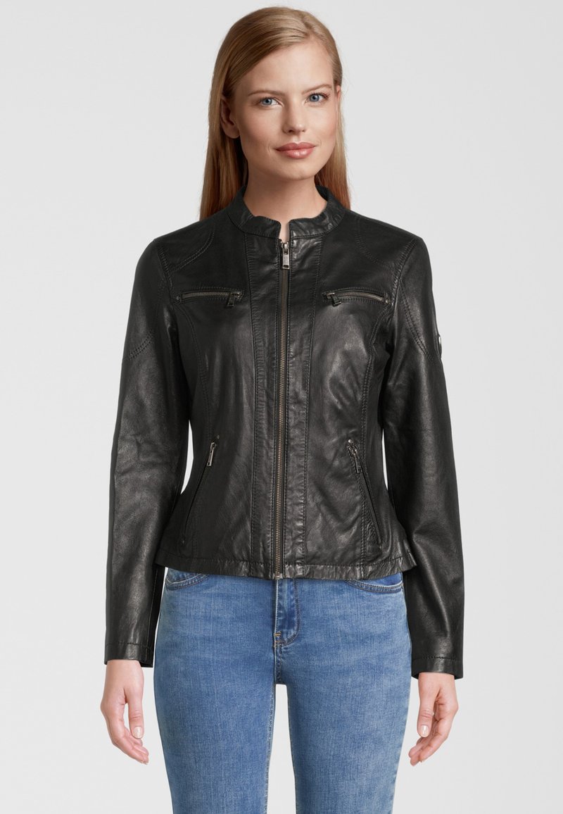 Schwarze Lederjacke mit einem taillierten Design, Stehkragen und Reißverschlusstaschen vorne. Glatte Textur und maßgeschneiderte Form, kombiniert mit blauen Jeans.