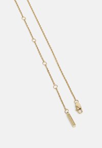 Collier chaîne en or composé de maillons circulaires, d'une plaque rectangulaire avec texte gravé, et d'une fermeture à mousqueton. Fini métallique lisse.