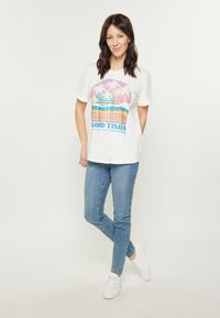Hvid kortærmet t-shirt med et farverigt grafisk motiv med palmer og teksten "GOOD TIMES". Sæt sammen med blå slim-fit jeans og hvide sneakers.