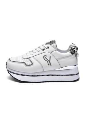 Sneaker sintetiche bianche con design perforato, dettagli in argento, logo sul lato e una suola spessa bicolore nera e bianca con dettagli testuali.
