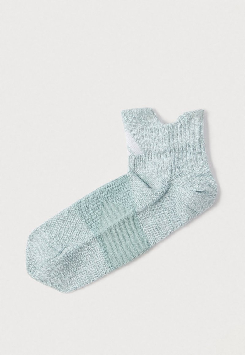 Φωτεινό πράσινο κάλτσα αστραγάλου με ριμπ υφή, ενισχυμένη μύτη και μοναδικό σχέδιο με διαφορετικά μοτίβα. Το υλικό φαίνεται μαλακό και ελαστικό.