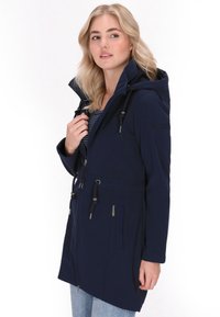 Parka impermeabile navy con cappuccio regolabile, chiusura con zip, due tasche frontali e vita regolabile. Texture liscia, design casual.
