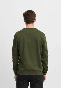 Oliven grøn sweatshirt med lange ærmer, ribbede manchetter og kant. Blødt, struktureret stoff og rund halsudskæring. Ingen synlige logoer eller mønstre.