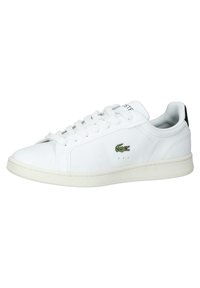 Baskets en cuir blanc avec des lacets blancs, une semelle basse et un logo crocodile vert sur le côté.