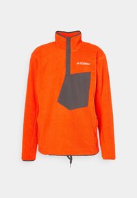 Oranje fleece pullover met een halve rits kraag, grijze borstzak en een trekkoord aan de onderkant. Logo op de bovenste linkerzijde. Zachte textuur en relaxte pasvorm.