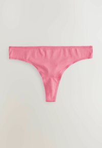 Un string en coton rose avec une texture lisse, doté d'une large ceinture élastique et d'un design minimaliste, présenté sur un fond clair.