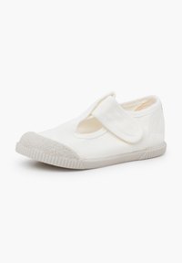 Witte canvas schoen met een gewatteerde grijze rubberen neuscap, klittenband over de wreef en een flexibele rubberen zool.