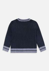 Neulepaita tummansinisessä värissä, jossa on teksturoitu kuvio. Harmaa ribbineck ja hihansuut tummilla raidoilla. Säännöllinen istuvuus, pitkät hihat.