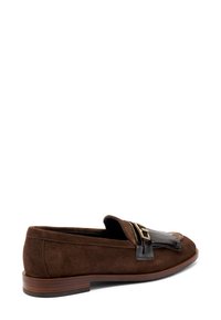 Mocassino in suede marrone con una fascia in pelle nera e un sottile dettaglio in oro, caratterizzato da punta rotonda e tacco in legno basso.