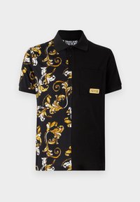 Svart kortermet polo-skjorte med utsmykket gull- og hvit blomstermønster på den ene siden og ensfarget svart stoff på den andre. Inkluderer lomme.
