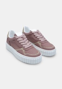 Mauve ja beezide siduri (lace-up) platvormi jooksujalatsid, millel on perforeeritud detailid ja paksud valged tekstuuriga tald, heledal taustal.