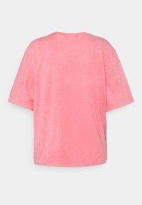 Camiseta de algodón rosa con un corte relajado, mangas cortas y una textura ligeramente deslavada. No hay logotipos ni patrones visibles en la parte trasera.