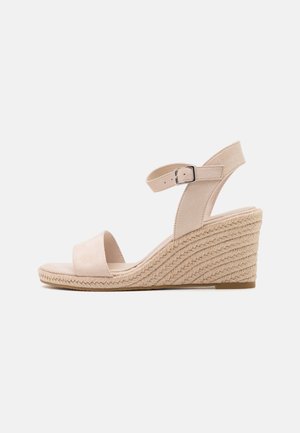Beige wedge sandals with soft suede straps; wide front band and adjustable ankle strap; woven jute detailing along the wedge heel.