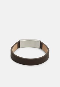 Brun läderarmband med en slät yta, som har ett silverfärgat rektangulärt metallspänne och en kontrasterande ljus läderinredning.