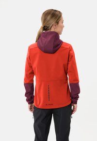 Rode en paarse damesjas met een rits aan de voorkant, verstelbare capuchon en een verticale stippenpatroon op de achterkant. Gemaakt van zachte, gestructureerde stof.