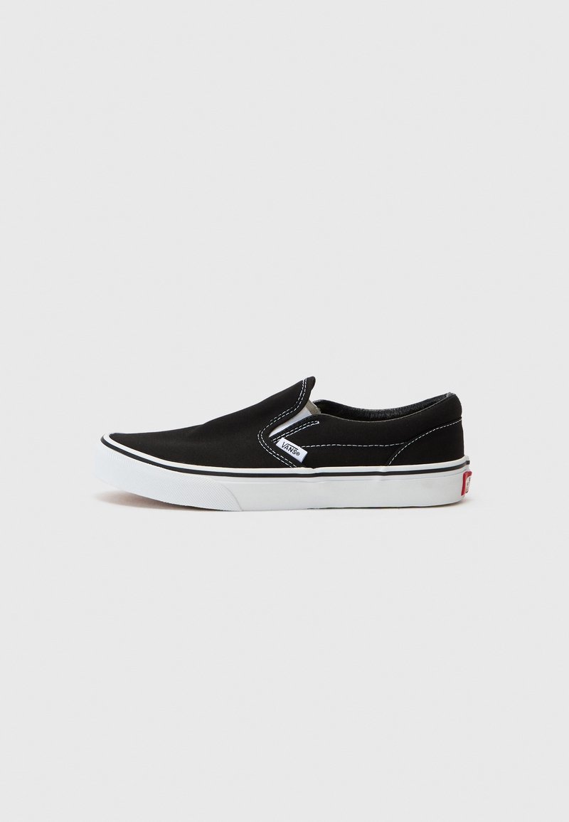 Fekete vászon slip-on cipő fehér varrással, fehér gumitalppal és egy kis logó címkével. Sima textúrával és minimalista dizájnnal rendelkezik.