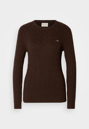 Brun ribbestrikket genser med rund hals, som har kabelstrikket tekstur og en liten brodert logo på brystet. Lange ermer.