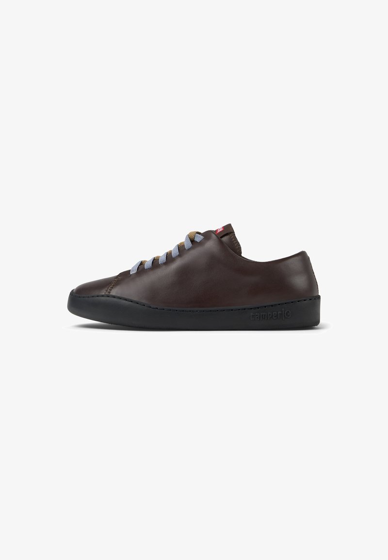 Brown leather sneaker with a smooth finish, round toe, blue and brown laces, and a black rubber sole. Features minimal branding on the side.