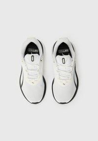 White athletic shoes with mesh textile upper, black accents, and prominent Puma logo. Features laces and rubber sole for stability.