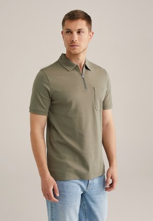 Olive green polo shirt with a short zip neck, chest pocket, and short sleeves, made from a smooth, lightweight fabric. Casual fit.