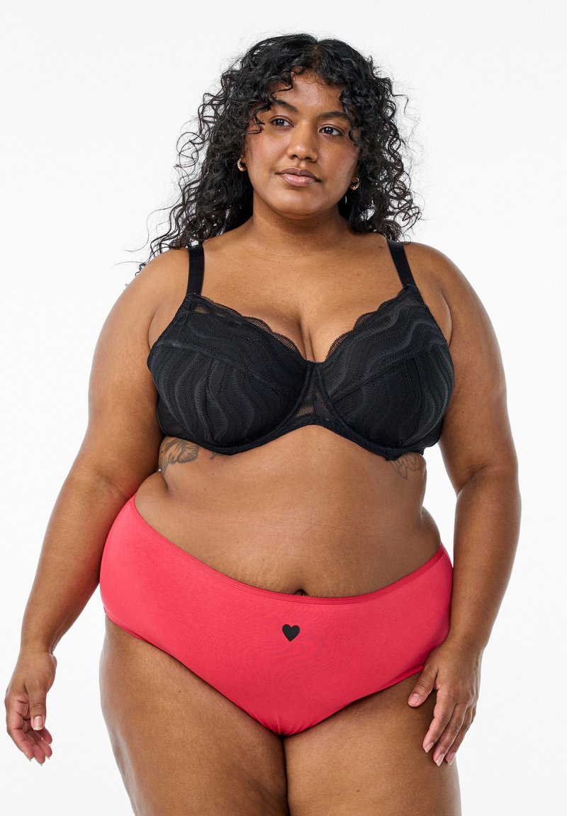 Black lace bra with wave pattern and adjustable straps, paired with red high-waisted underwear featuring a small black heart detail.