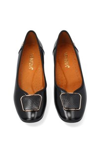 Černé baleríny s lesklým povrchem, s texturovaným čtvercovým dekorem a zlatým kováním. Interiér má béžové polstrované vnitrní vyložení s perforacemi.