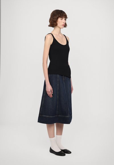 Must have mustrõngus kootud must tank top õhukeste rihmadega, millele on sobitatud tume denim A-line seelik, millel on nähtav õmblemine ja ääre detail.