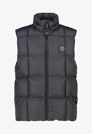 Chaleco acolchado negro con cuello alto, cierre frontal de cremallera y grandes secciones acolchadas. Presenta un parche con el logotipo en el pecho izquierdo.