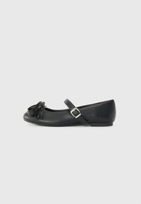 Mustat nahka ballet-tasapohjat, joissa on pyöristetty kärki, koristeellinen fringed yksityiskohta ja sivu-solki. Minimalistinen muotoilu ja sileä pinta.