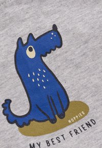 Cartoon blauwe hond met roomkleurige vlekken, zittend op een bruine plek, vergezeld van de tekst "MIJN BESTE VRIEND" en "MOPPIES."
