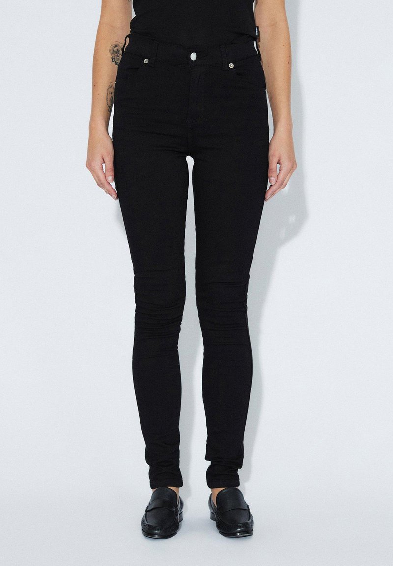 Černé skinny džínsy z denimu s hladkou texturou, vysokým pasem, pětivreckovým designem a jedním předním knoflíkem.