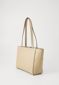 Beige totebag med preget geometrisk mønster, glatt tekstur og svart kant. Har lange, flate skulderremmer og firkantet form.