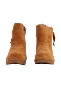Tan suède enkelboots met een vlakke zool, zijrits en een decoratieve strikaccent op de hak. Gladde textuur en ronde teenvorm.
