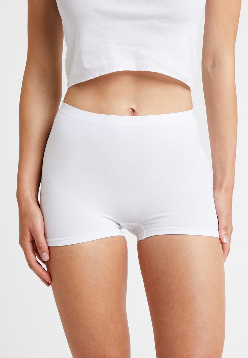 Shorts bianchi in cotone elasticizzato con un design aderente, texture liscia e una vita elastica. Progettati per comfort e facilità di movimento.