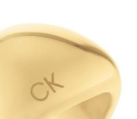 Anello in metallo dorato con superficie liscia e lucida, e logo "CK" inciso. Design arrotondato con una banda larga.