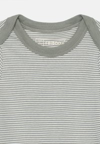 Stripete mønstre grå jumpsuit med rund hals og korte ermer. Tøyet er mykt, og kragen har en ensfarget grå detalj.