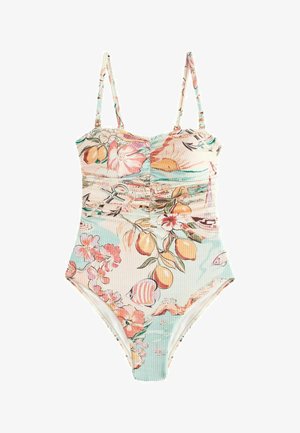 Maillot de bain une pièce à fines bretelles, imprimé floral et fruité comprenant des citrons, des poissons et un soleil sur un fond pastel clair.
