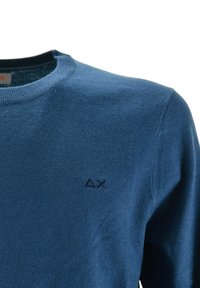 Maglione a maniche lunghe blu in maglia con scollo rotondo e piccoli simboli triangolari neri ricamati a forma di X sul petto.