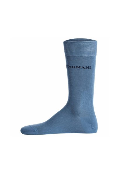 Chaussette bleue mi-mollet avec bord-côtes et logo noir "ARMANI" sur le côté sur fond blanc.