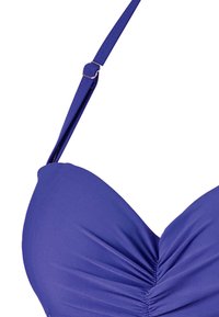 Haut de bikini violet avec bonnets moulés, détails froncés au centre, bretelles réglables et quincaillerie métallique sur la bretelle. Texture de tissu lisse.
