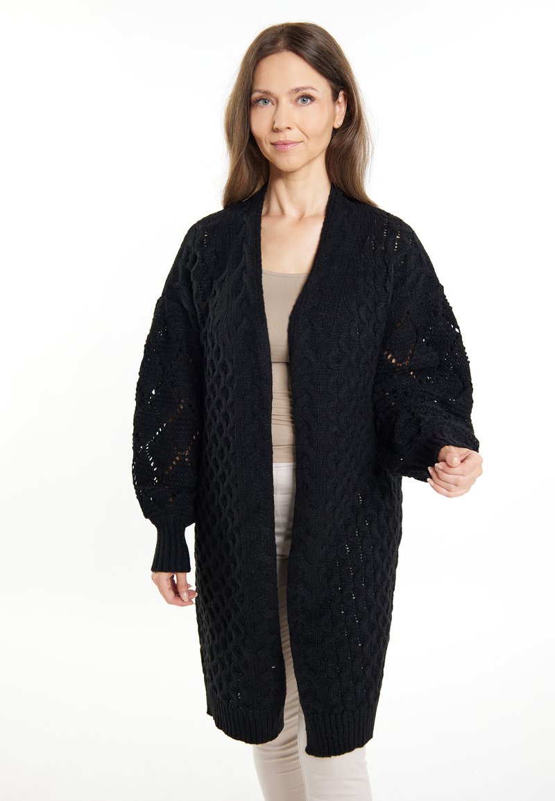 Cardigan nero lavorato a maglia con vestibilità ampia, caratterizzato da un motivo a trecce testurizzato e polsini a coste. Stile aperto sul davanti per un facile stratificazione.