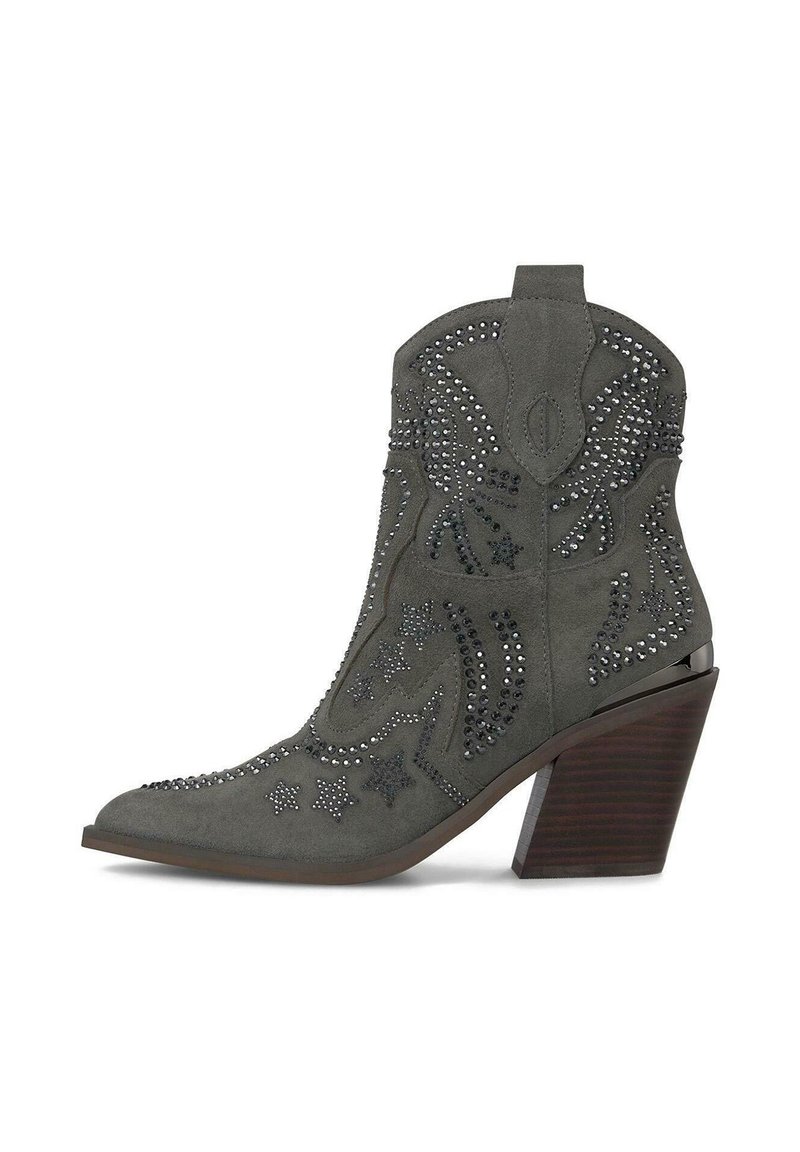 Bota de cowboy de ante gris con punta afilada, adornada con tachuelas plateadas en patrones de estrellas y flores, y un tacón de madera decorativo.