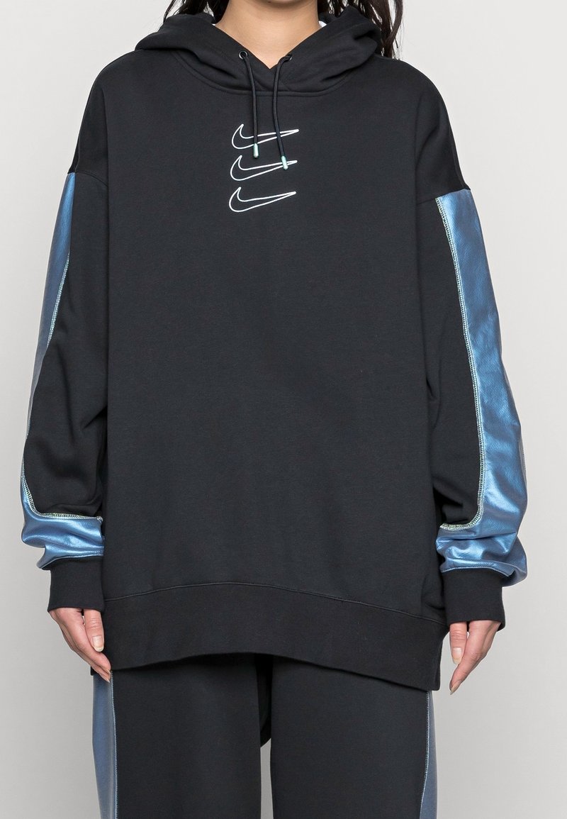 Svart hoodie med dragkedja och blåa satinsidopaneler samt Nike-logotyp i mitten. Har en justerbar huva och ribbade ärmslut.
